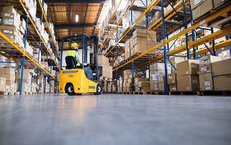 a fork lift moving boxes in a commercial warehouse